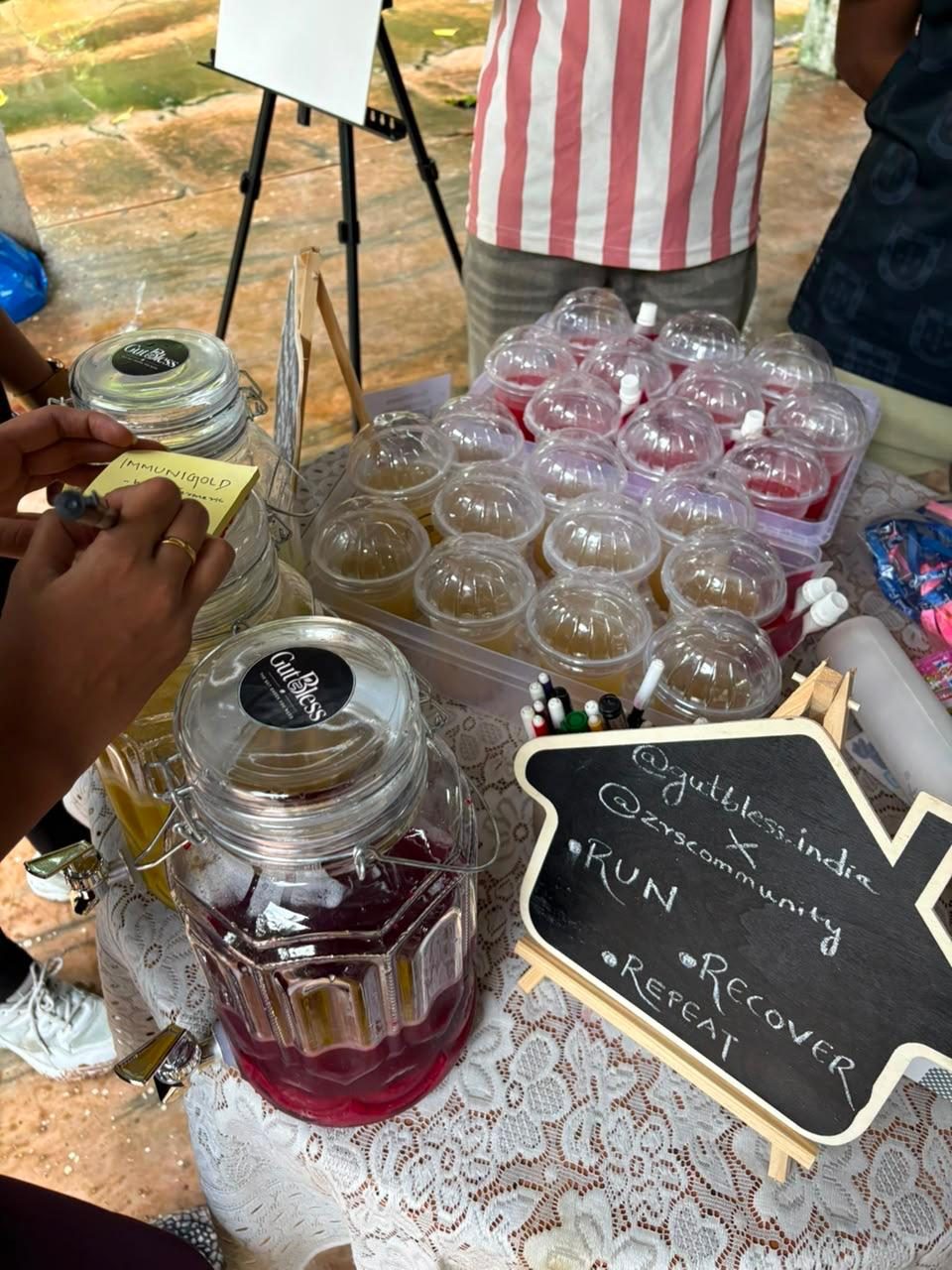 GutBless stall setup with juices and a Run, Recover, Repeat chalkboard for the ZRS Community run