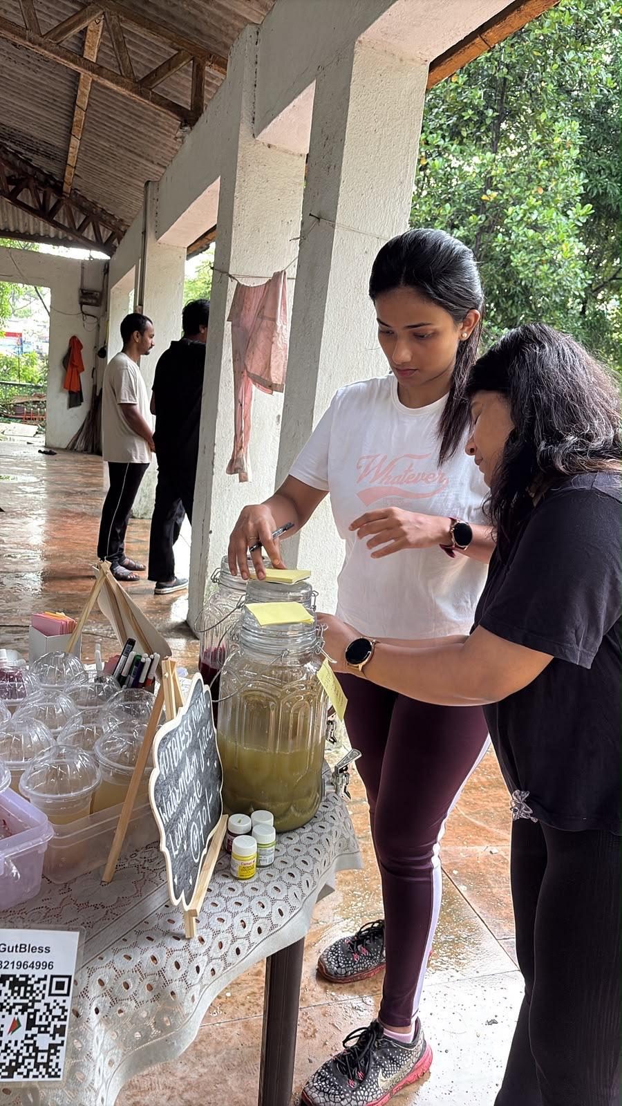 The GutBless team serving fresh juice from dispensers at an event stall